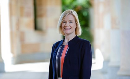 Professor Brenda Gannon from the waist up with UQ sandstone visible behind